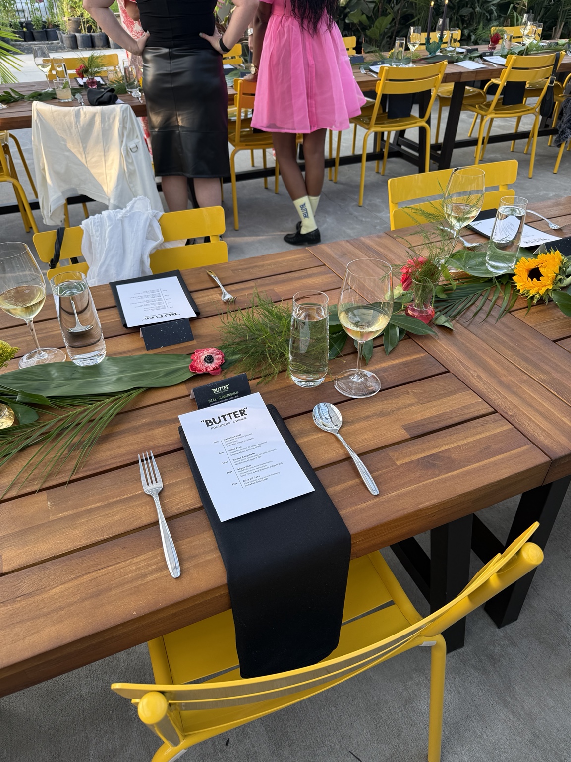BUTTER Founders' Dinner table setting with menus, flowers and yellow chairs